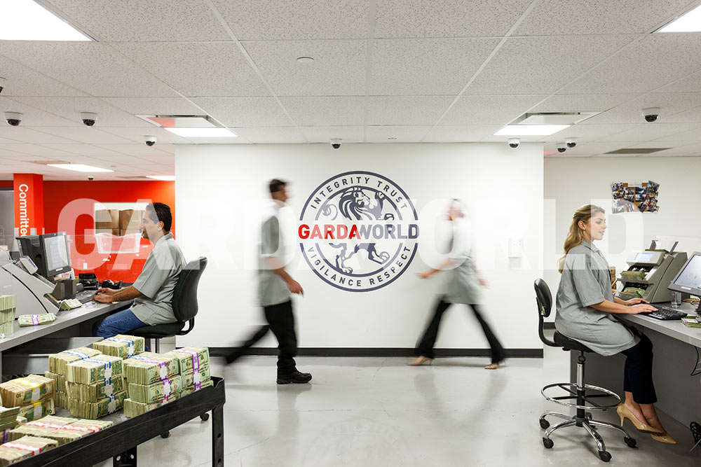 Cash Services, Counting Rooms with employees working, GardaWorld’s crest on the wall (men and women)