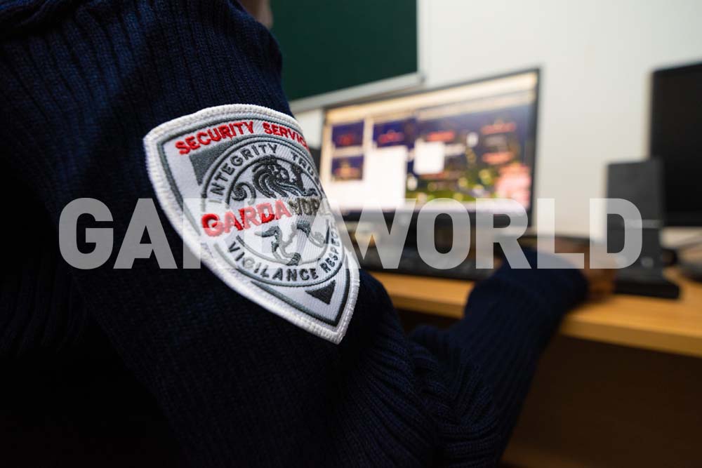 Agent on computer, Focus on GardaWorld Crest on uniform