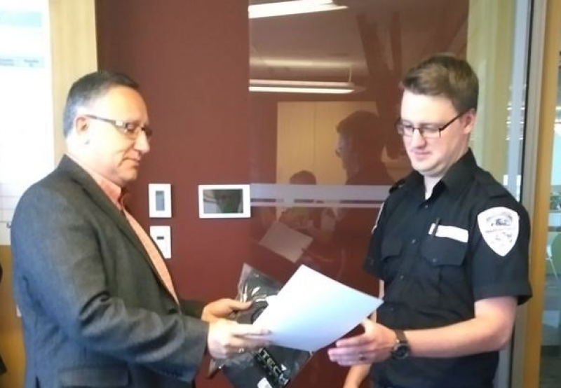 Edmonton Airports Director of Safety & Security, Jason Sangster, presents GardaWorld Security Officer, Aaron Wray with a certificate.  