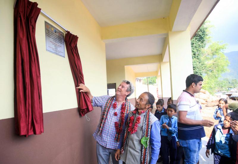 Deux hommes dévoilent une plaque à la nouvelle école secondaire Niranjana à Milanbazar, au Népal, reconstruite après le tremblement de terre de 2015