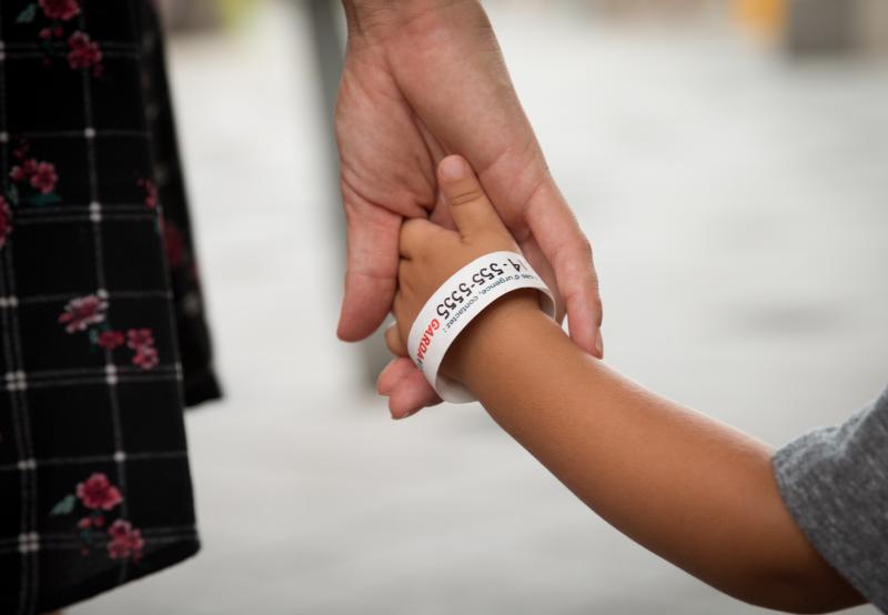 woman holdingthe hand of a child that's wearing a gardaworld bracelet