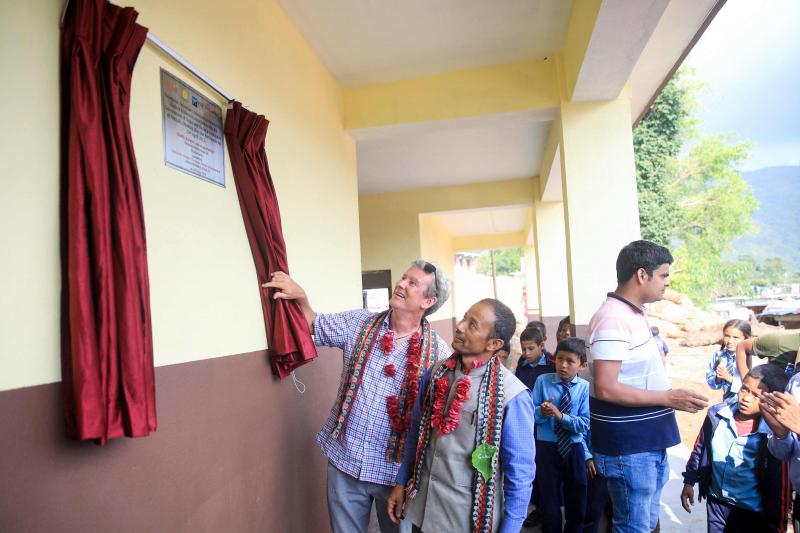 Deux hommes dévoilent une plaque à la nouvelle école secondaire Niranjana à Milanbazar, au Népal, reconstruite après le tremblement de terre de 2015